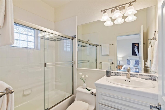 full bathroom with vanity, combined bath / shower with glass door, and toilet