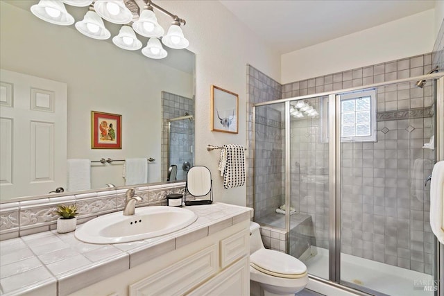 bathroom featuring an enclosed shower, vanity, and toilet