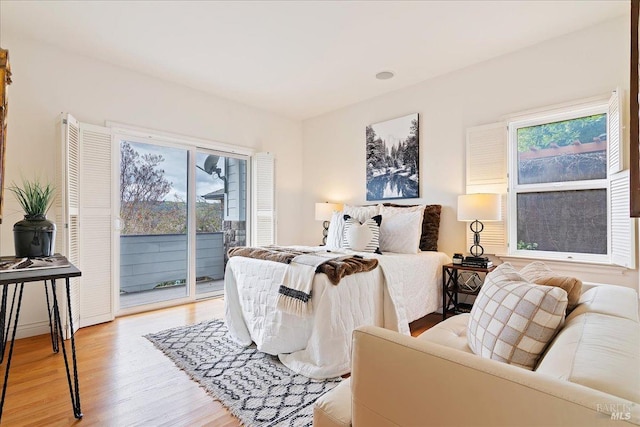 bedroom featuring access to exterior and light hardwood / wood-style flooring