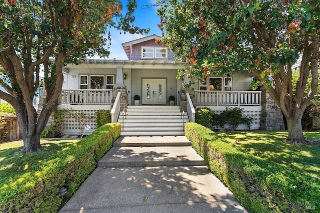 view of front of home with a front yard and covered porch