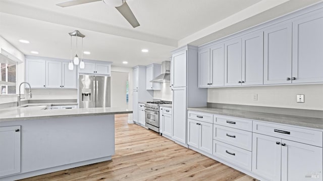 kitchen featuring white cabinetry, hanging light fixtures, wall chimney exhaust hood, and appliances with stainless steel finishes