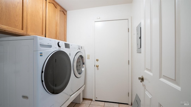 washroom featuring cabinets, light tile patterned floors, electric panel, and washer and clothes dryer