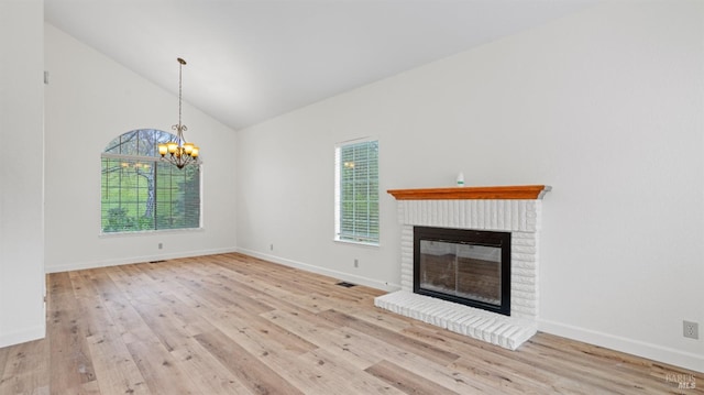 unfurnished living room with light hardwood / wood-style flooring, a brick fireplace, and plenty of natural light