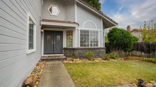 property entrance with a lawn