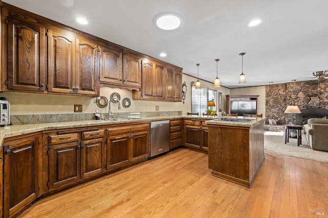 kitchen with dishwasher, sink, hanging light fixtures, kitchen peninsula, and light wood-type flooring