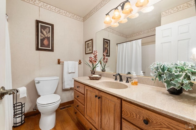 bathroom with hardwood / wood-style flooring, vanity, and toilet