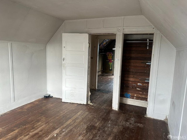 additional living space featuring lofted ceiling and dark hardwood / wood-style floors