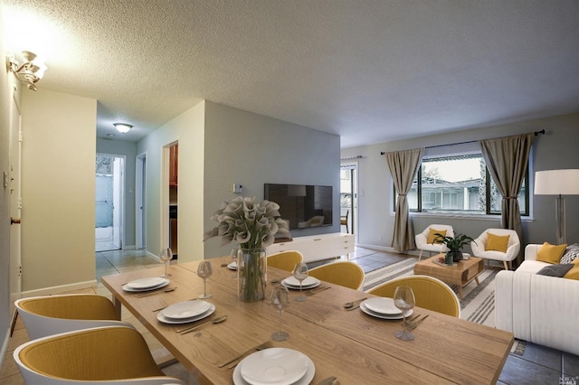 tiled dining room featuring a textured ceiling