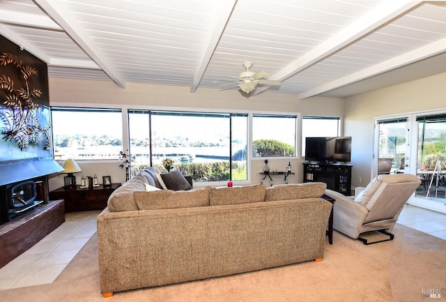 living room featuring beamed ceiling, ceiling fan, a healthy amount of sunlight, and light tile patterned floors