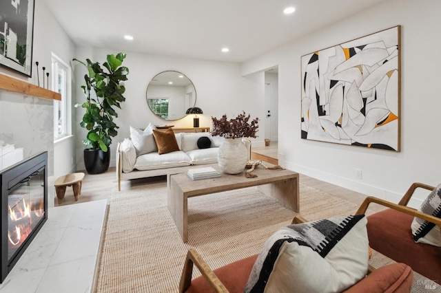 living room with a tile fireplace and light hardwood / wood-style floors