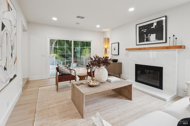 living room with light hardwood / wood-style flooring and a high end fireplace