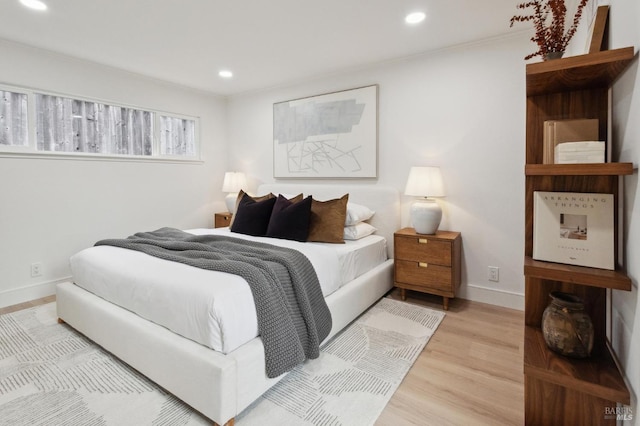 bedroom featuring crown molding and light hardwood / wood-style floors