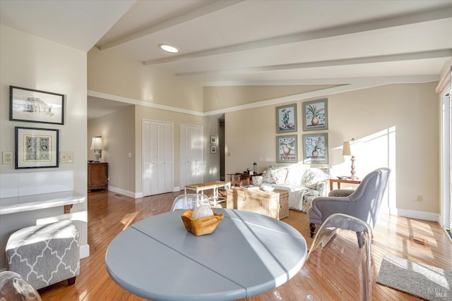 dining area with light hardwood / wood-style floors and lofted ceiling with beams