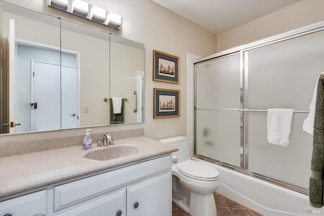 full bathroom featuring toilet, vanity, and bath / shower combo with glass door