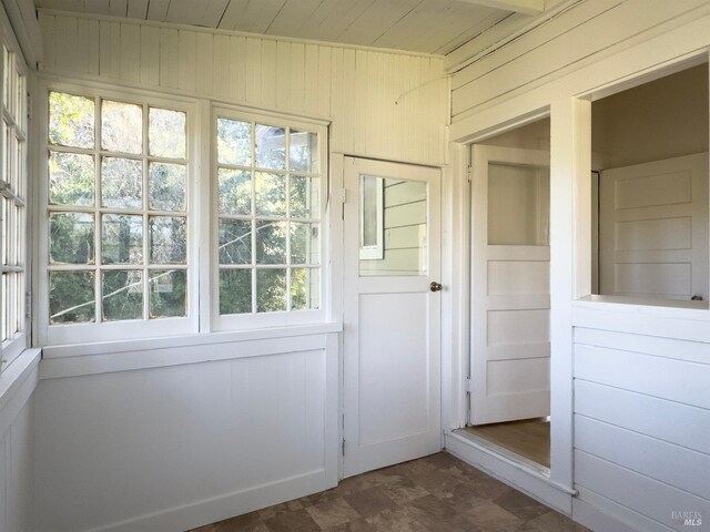 entryway with a healthy amount of sunlight and wood walls