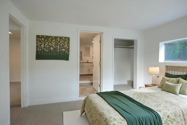 carpeted bedroom with a closet and ensuite bathroom