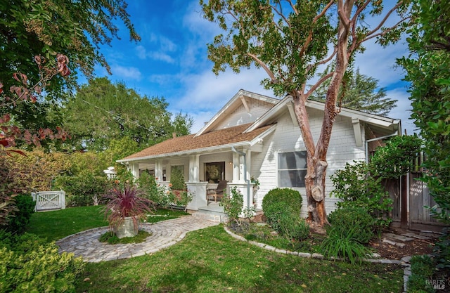 view of front of property featuring covered porch and a front yard