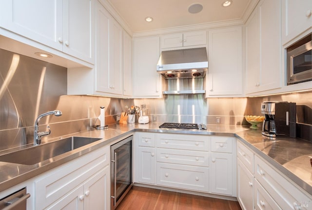 kitchen with sink, white cabinetry, ventilation hood, stainless steel appliances, and beverage cooler