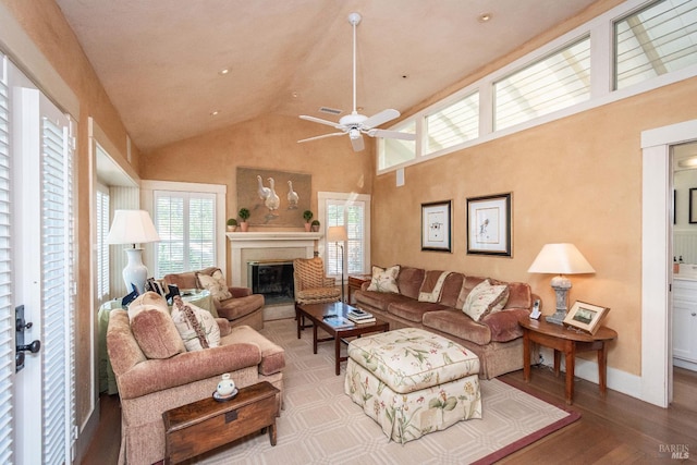 living room with hardwood / wood-style flooring, high vaulted ceiling, and ceiling fan