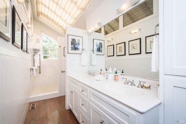 bathroom featuring tiled shower, wood-type flooring, and vanity