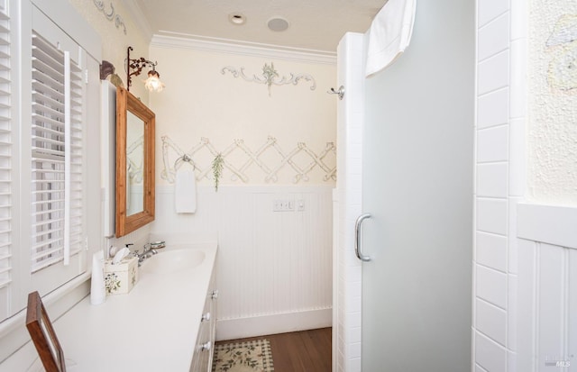 bathroom featuring vanity, wood-type flooring, ornamental molding, and walk in shower