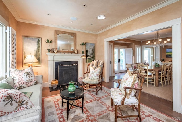 living room featuring hardwood / wood-style flooring, ornamental molding, and a chandelier