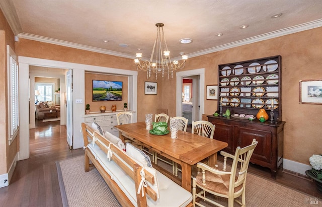 dining area featuring crown molding, a chandelier, and dark hardwood / wood-style flooring