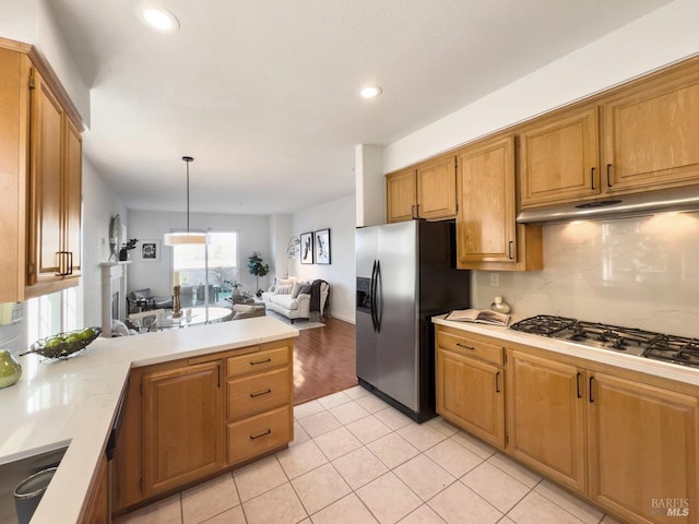 kitchen with sink, light tile patterned floors, appliances with stainless steel finishes, pendant lighting, and decorative backsplash