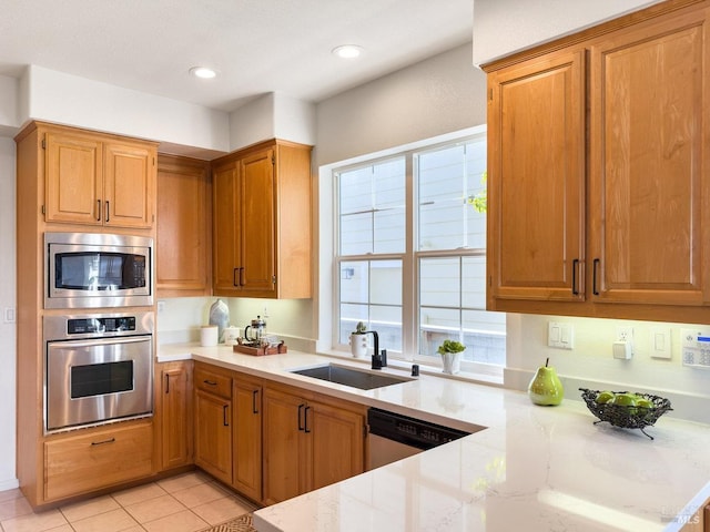 kitchen featuring stainless steel appliances, light tile patterned flooring, sink, and kitchen peninsula