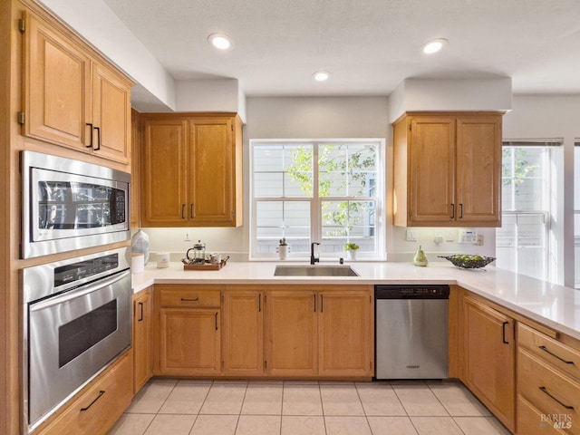 kitchen with appliances with stainless steel finishes, sink, and light tile patterned floors