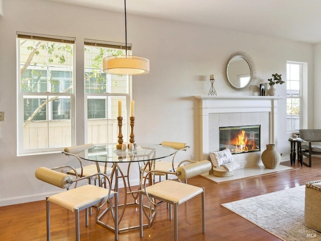 dining area with hardwood / wood-style flooring and a fireplace