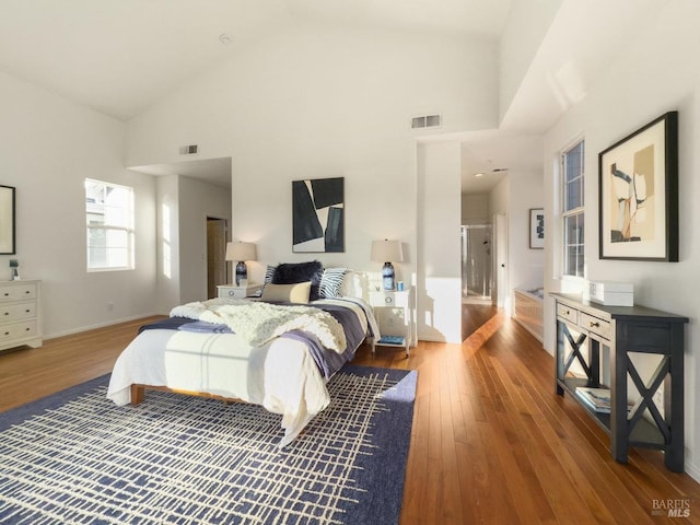 bedroom featuring wood-type flooring and high vaulted ceiling