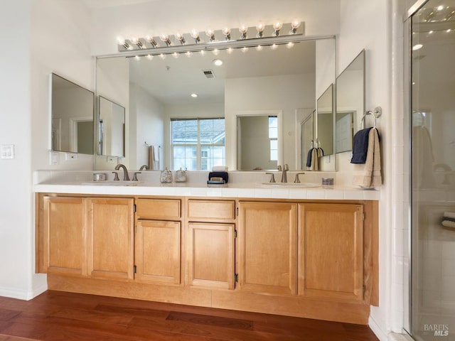 bathroom with vanity, wood-type flooring, and a shower with shower door