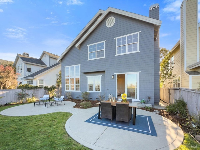 rear view of house with a patio and a lawn