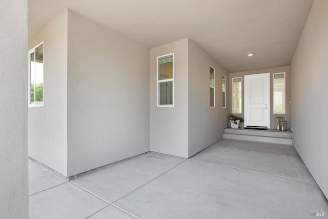 view of exterior entry with a patio area