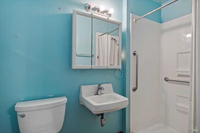 bathroom featuring sink, toilet, and a shower with shower curtain