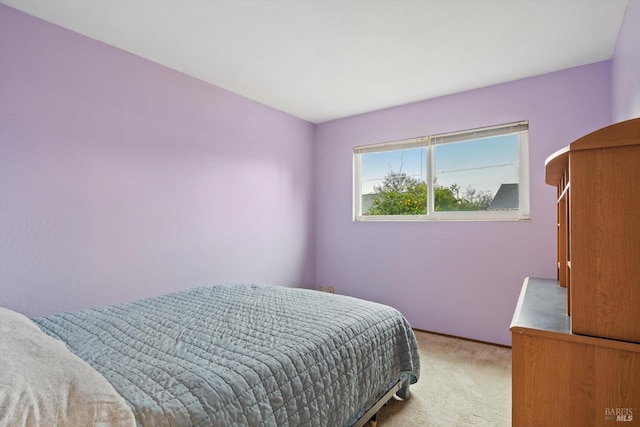 bedroom with baseboards and light carpet