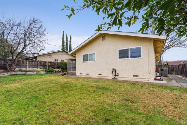 rear view of property featuring a patio, a sunroom, and a yard