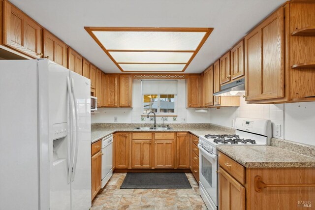 kitchen featuring sink, white appliances, and decorative backsplash