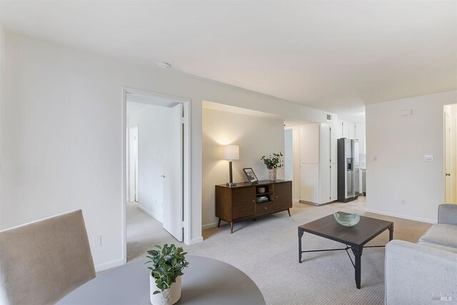 living room featuring stacked washer and dryer and light carpet