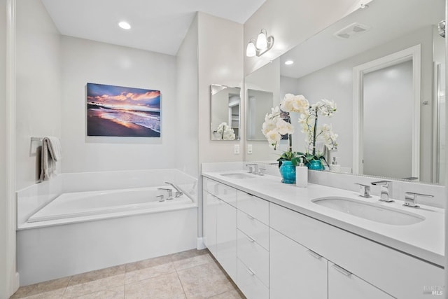 bathroom featuring tile patterned flooring, vanity, and a tub