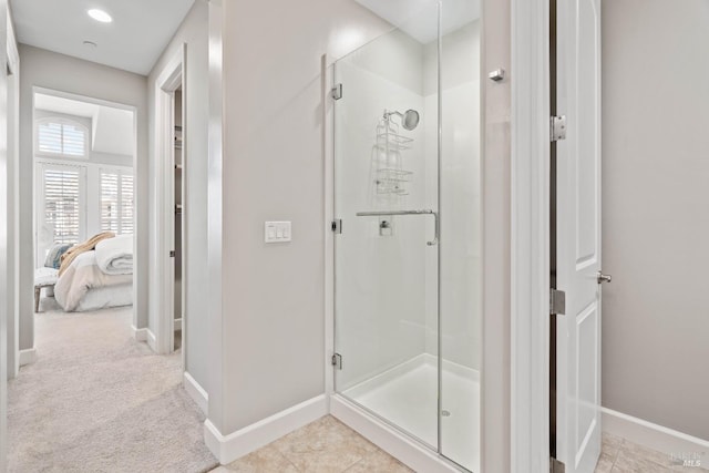 bathroom with an enclosed shower and tile patterned floors