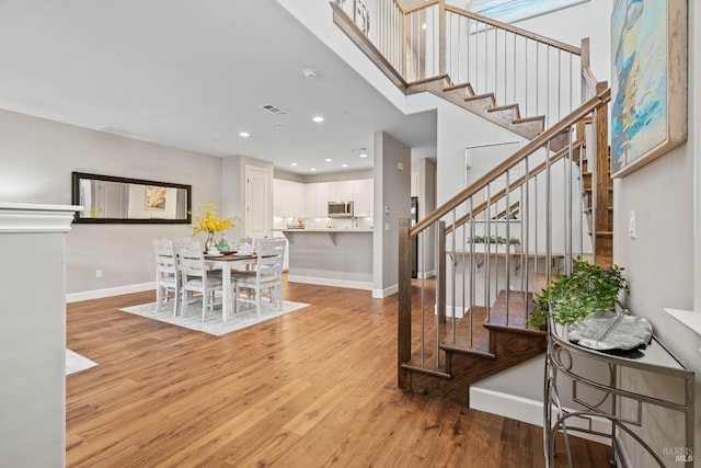 interior space featuring a high ceiling and light hardwood / wood-style flooring