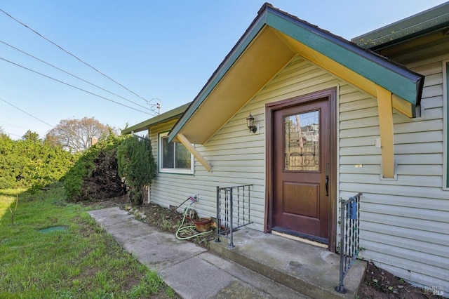 doorway to property with a lawn