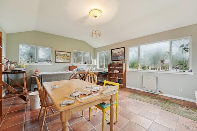 dining space featuring vaulted ceiling and an inviting chandelier