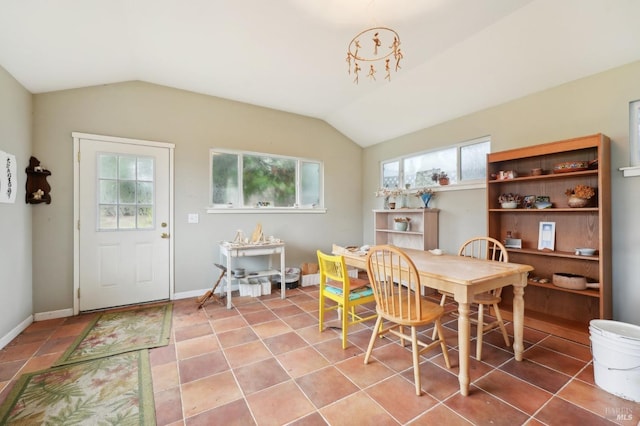 dining room with tile patterned flooring and vaulted ceiling