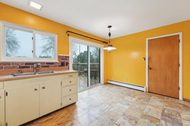 kitchen with sink, a baseboard heating unit, pendant lighting, and backsplash