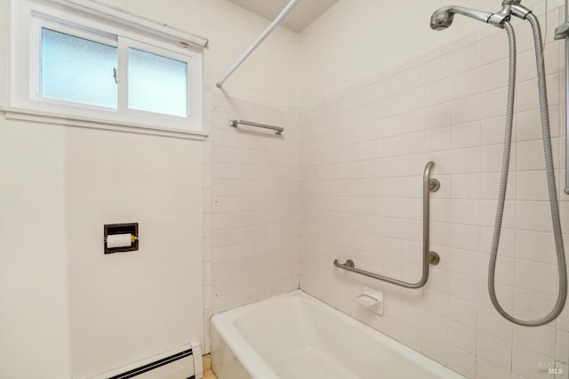 bathroom with a baseboard radiator and tiled shower / bath