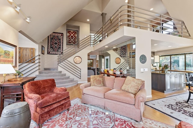 living room featuring high vaulted ceiling and light wood-type flooring