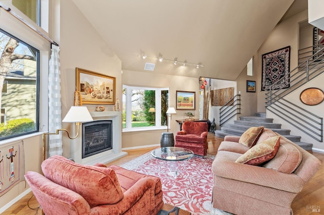 3057 Saint Helena Hwy N, Saint Helena, CA 94574 - living room featuring stairway, a glass covered fireplace, high vaulted ceiling, baseboards, and rail lighting